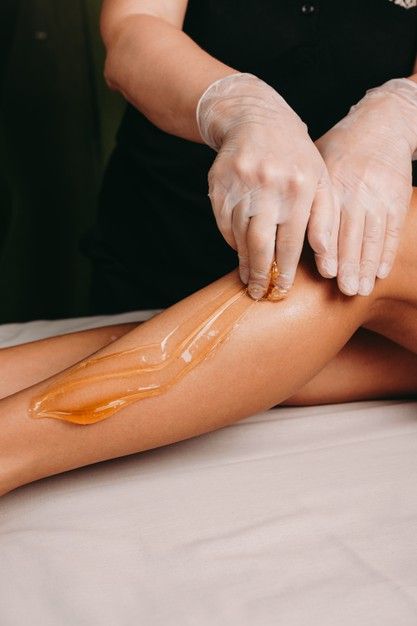 Sugaring procedure on legs done by a spa specialist during a procedure at the salon _ Premium Photo